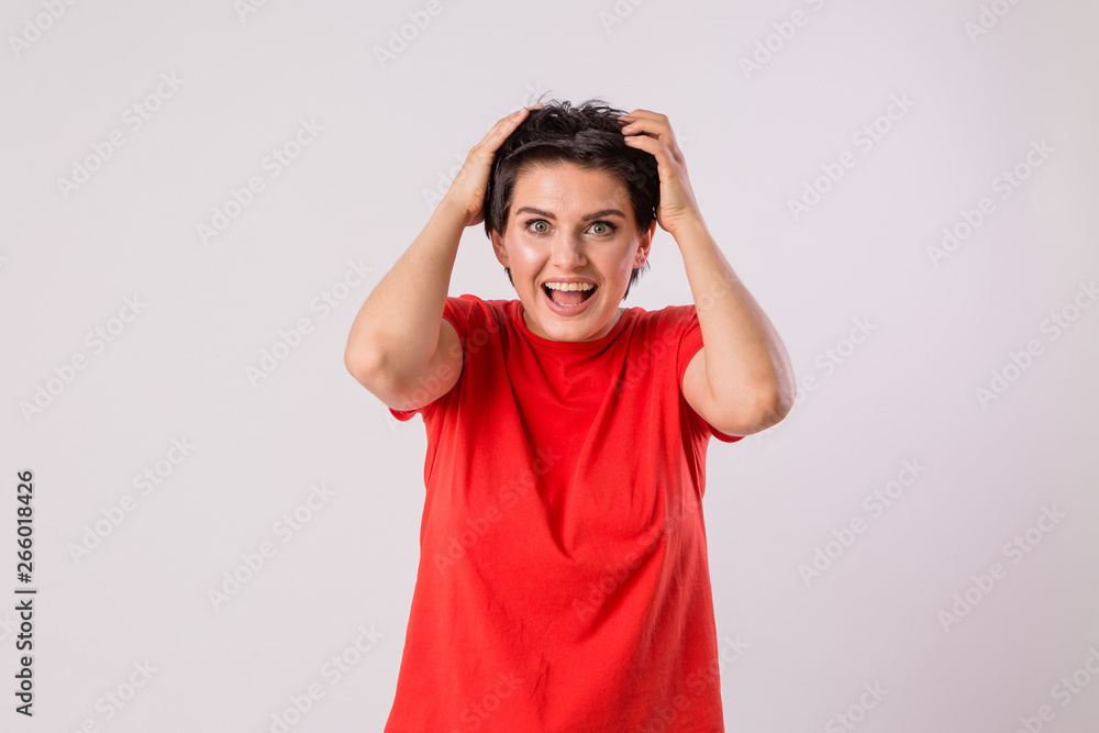 Human emotions and feelings.People, youth and happiness.charming young woman model smiling widely with her white straight teeth while holding her hands to her face posing in the Studio Human emotions and feelings.People, youth and happiness.charming young woman model smiling widely with her white straight teeth while holding her hands to her face posing in the Studio
