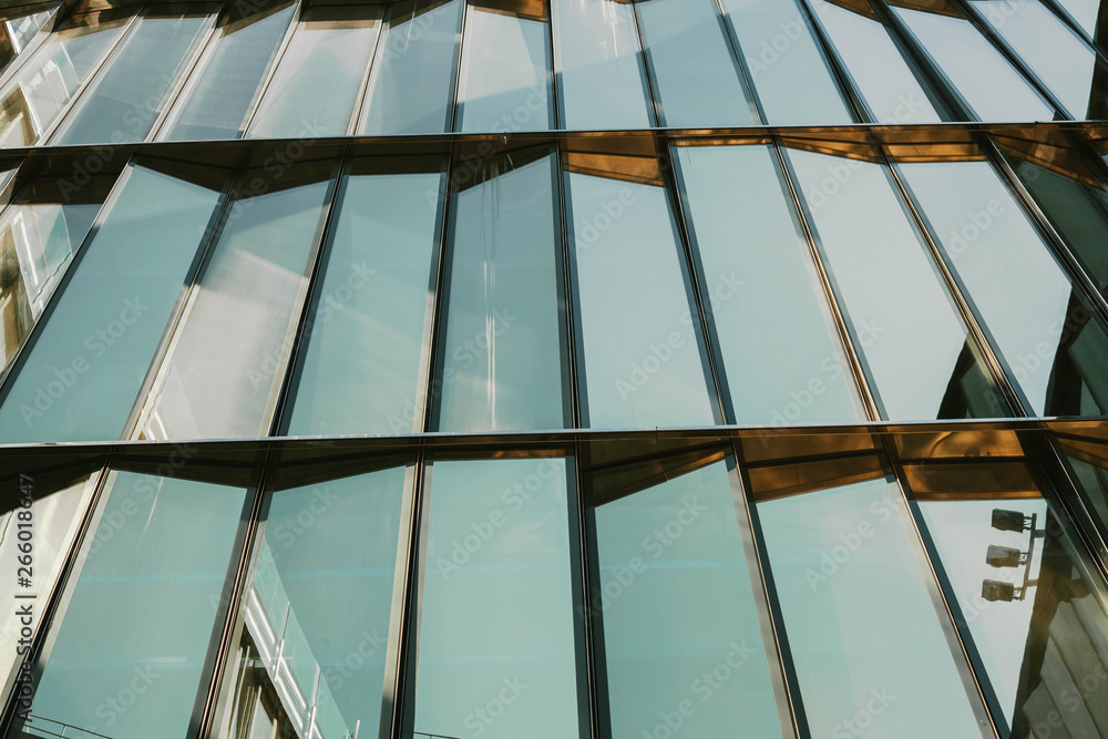 Obraz premium Glass window of a building with black aluminum frames, blue tone as background.