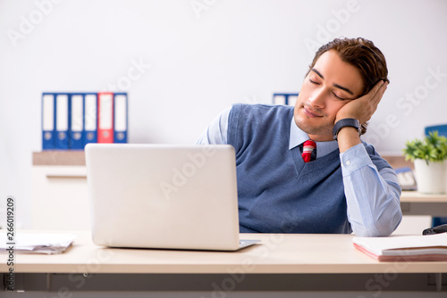 Young handsome employee working in the office 