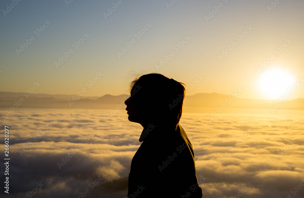 silhoutette of a young woman in the mountains during sunrise silhoutette of a young woman in the mountains during sunrise
