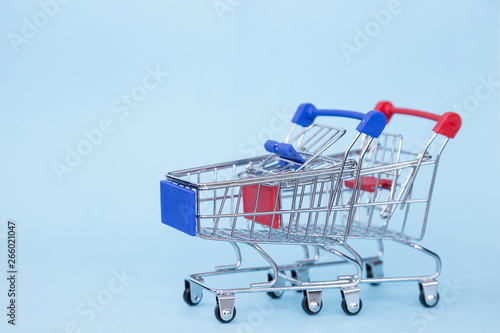 Empty grocery cart on wheels on a blue background