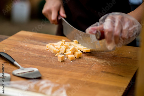 hands cut the cheese into pieces with a special knife