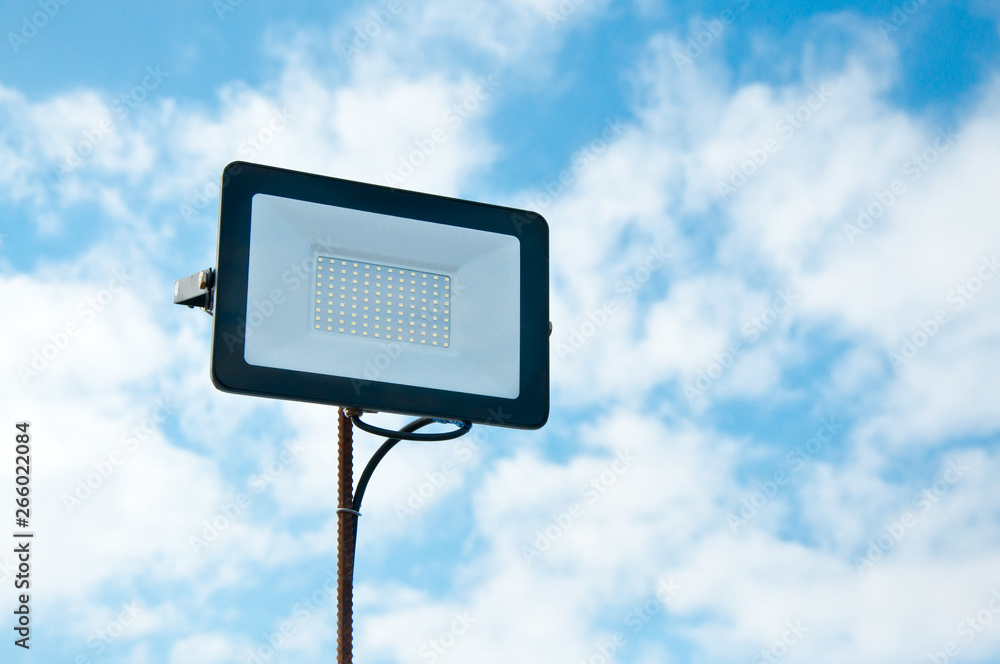 LED spotlight against the blue sky. Lighting area. The use of technology in modern construction. LED spotlight against the blue sky. Lighting area. The use of technology in modern construction.
