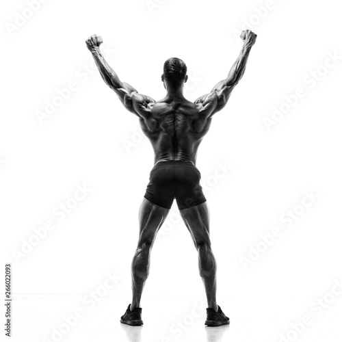 Black and White image of Strong Muscular Men Flexing Muscles from the Back. He is showing back muscles development