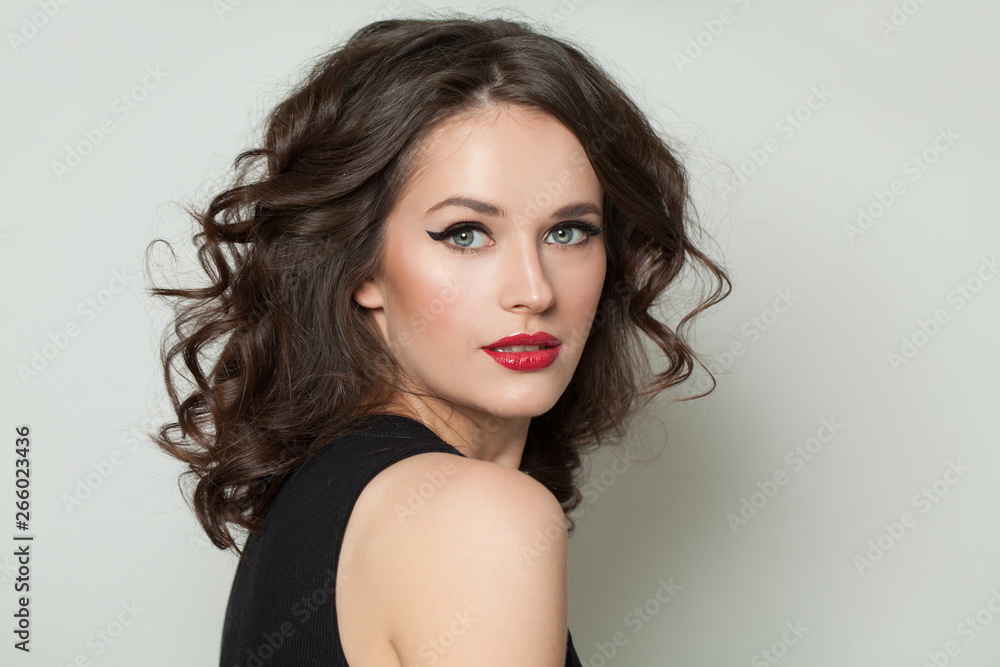 Beautiful sexy woman looking at camera. Pretty model with makeup and brown curly hair portrait Beautiful sexy woman looking at camera. Pretty model with makeup and brown curly hair portrait