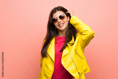 Teenager girl over pink wall with glasses and smiling © luismolinero