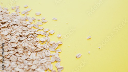 healthy diet, the concept. Grain oatmeal on a Yellow background. Oat flakes scattered