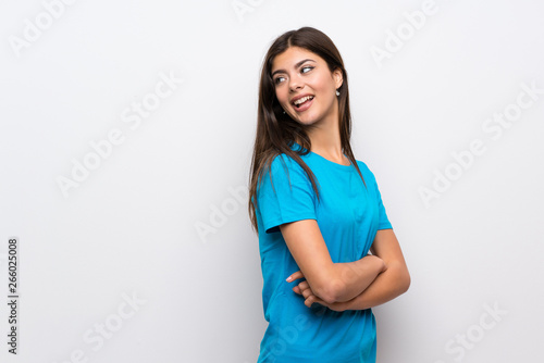 Teenager girl with blue shirt with arms crossed and happy © luismolinero
