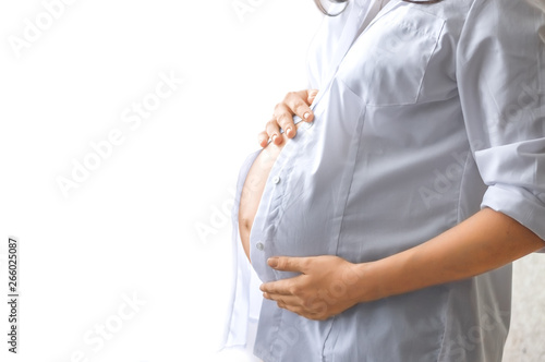 Belly of a pregnant woman. Hands on the stomach. Waiting for the baby. Copy space. Selective focus.