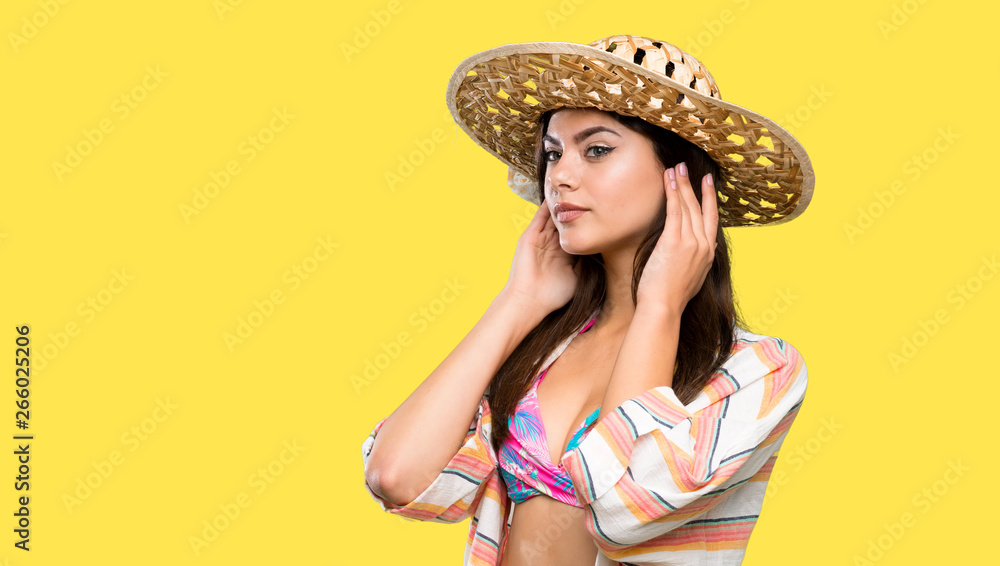 Teenager girl on summer vacation having doubts and thinking over isolated yellow background Teenager girl on summer vacation having doubts and thinking over isolated yellow background
