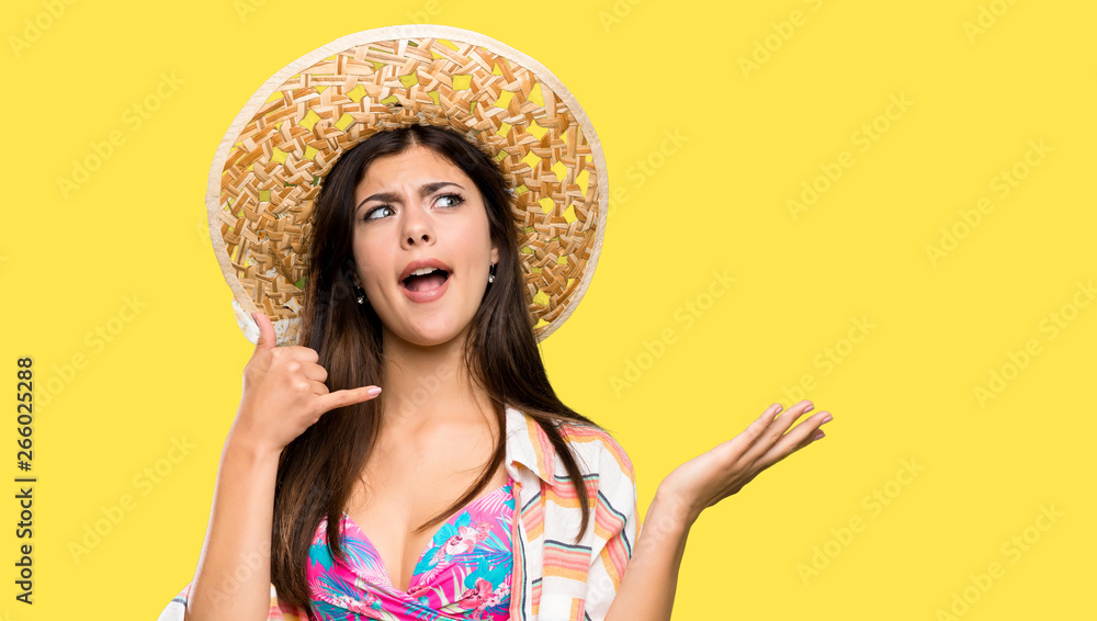 Teenager girl on summer vacation making phone gesture and doubting over isolated yellow background Teenager girl on summer vacation making phone gesture and doubting over isolated yellow background