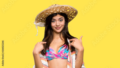 Teenager girl on summer vacation with surprise facial expression over isolated yellow background
