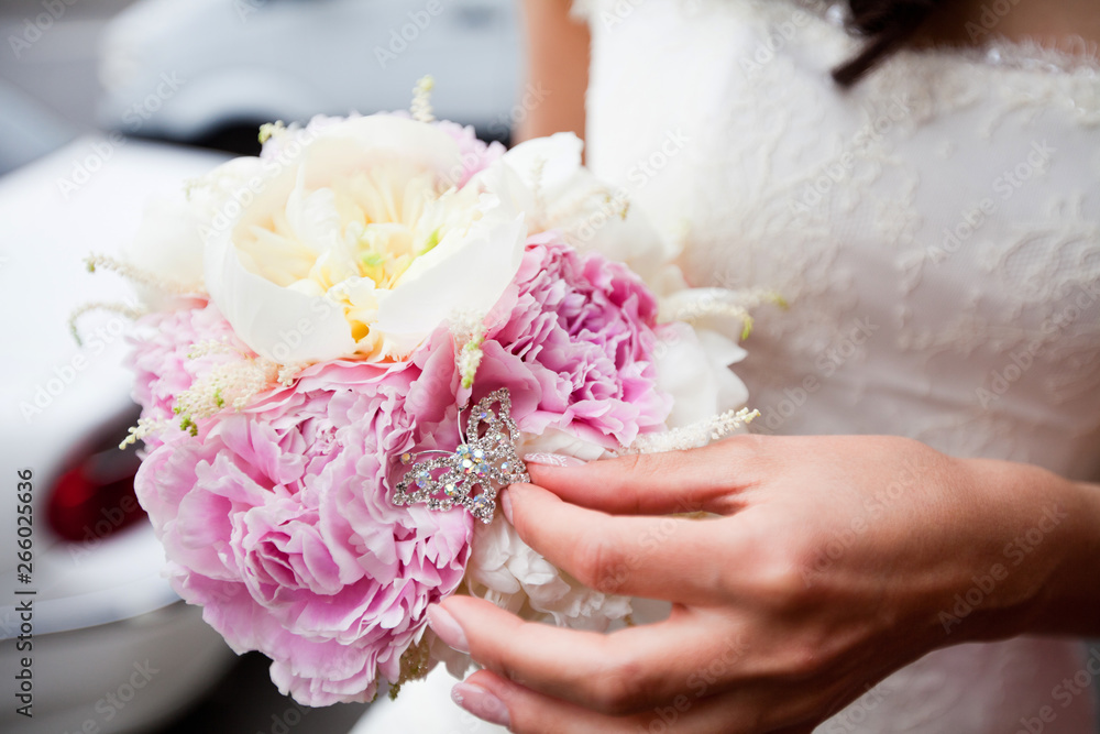 Refined bouquet of white and pink peonies in the hands of an unrecognizable bride Refined bouquet of white and pink peonies in the hands of an unrecognizable bride