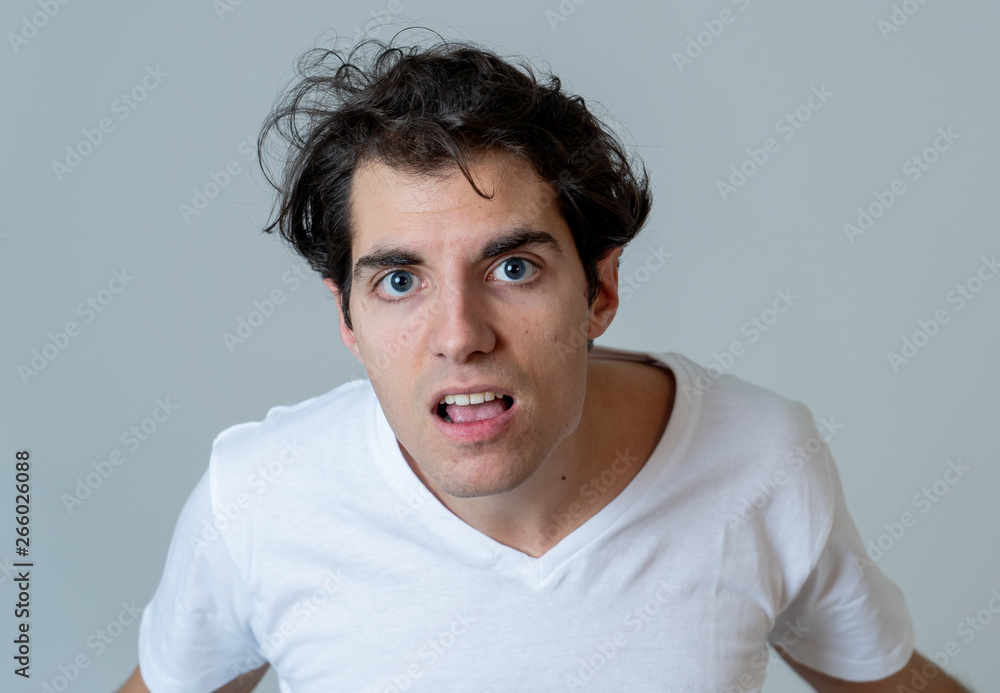 Portrait of a handsome young man with furious face looking disgusted. Human expressions and emotions Portrait of a handsome young man with furious face looking disgusted. Human expressions and emotions