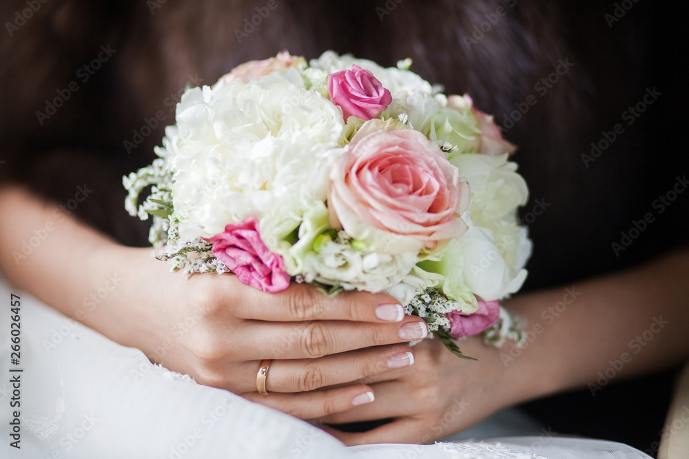 Beautiful bridal bouquet of peonies and pink roses in the hands of an unrecognizable bride Beautiful bridal bouquet of peonies and pink roses in the hands of an unrecognizable bride