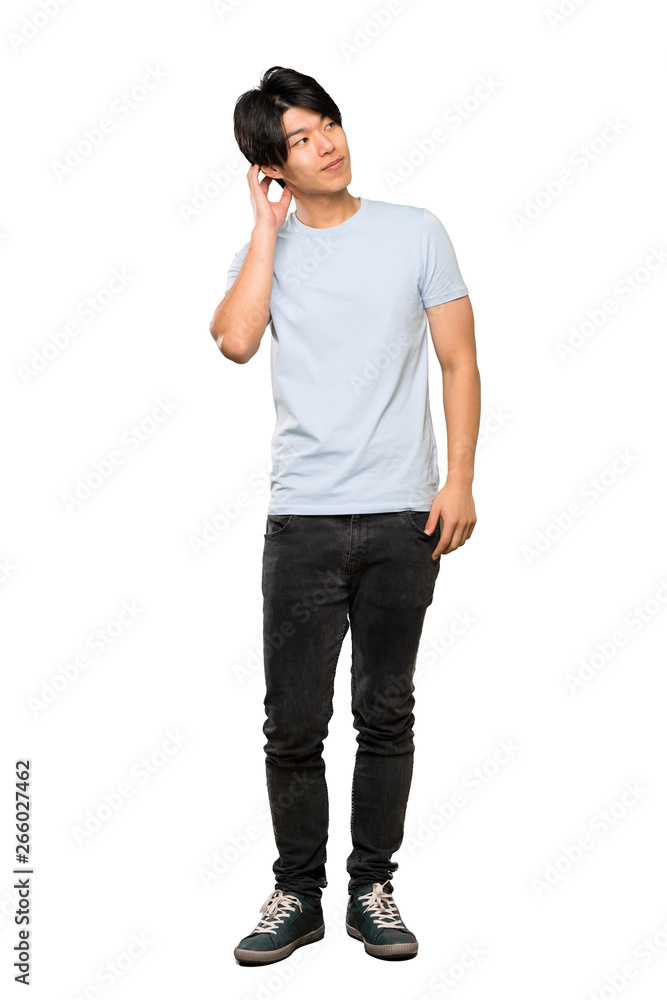 A full-length shot of a Asian man with blue shirt thinking an idea over isolated white background A full-length shot of a Asian man with blue shirt thinking an idea over isolated white background