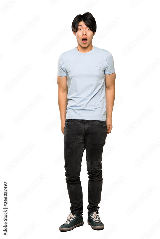 A full-length shot of a Asian man with blue shirt with surprise facial expression over isolated white background A full-length shot of a Asian man with blue shirt with surprise facial expression over isolated white background