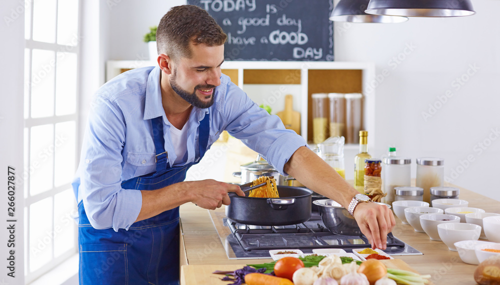 Smiling and confident chef standing in large kitchen Smiling and confident chef standing in large kitchen