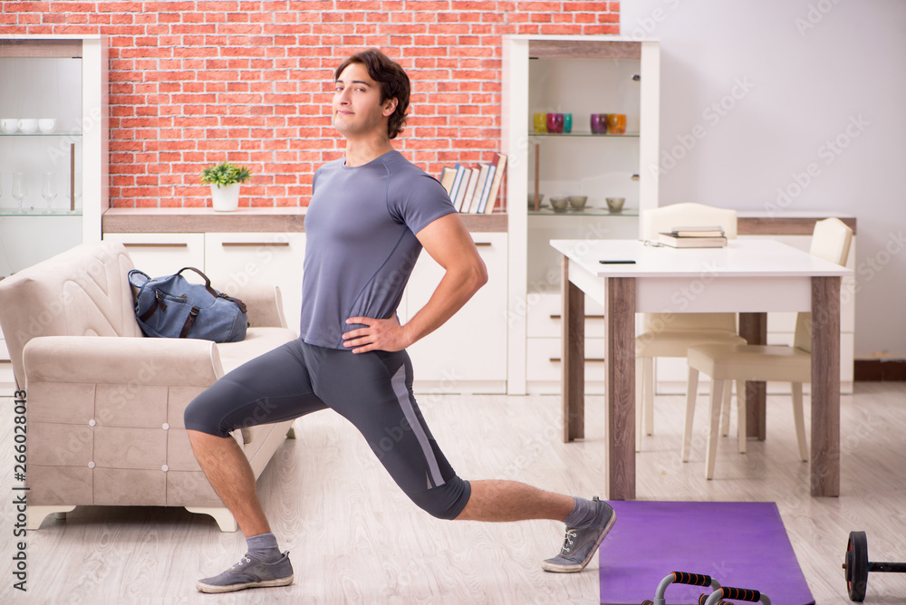Young handsome man doing sport exercises at home Young handsome man doing sport exercises at home