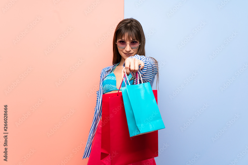 Young woman in bikini holding a lot of shopping bags