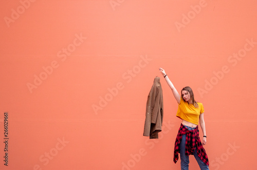 young stylish girl throws out on orange background
