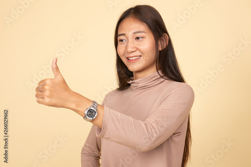 Asian woman thumbs up and smile.