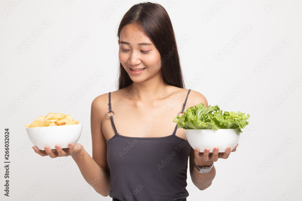 Young Asian woman with potato chips and salad. Young Asian woman with potato chips and salad.