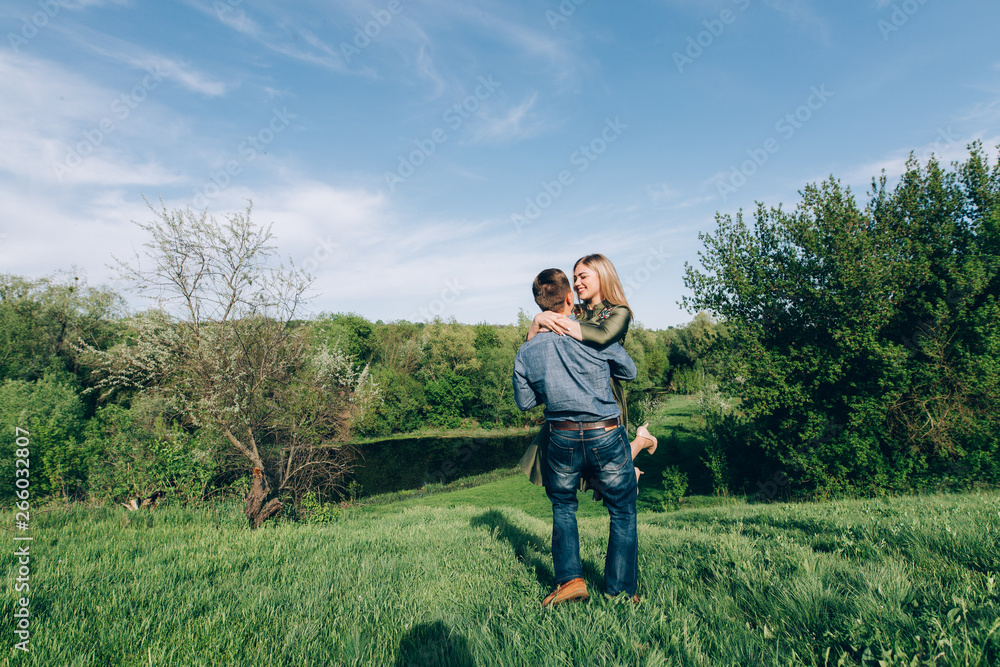 Loving guy and girl kisses in nature.concept of love story outdoor.Lovers Walking in spring park.stylish couple in love hugging on a walk in spring