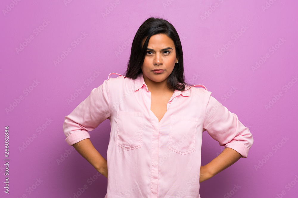 Young Colombian girl over purple wall angry Young Colombian girl over purple wall angry
