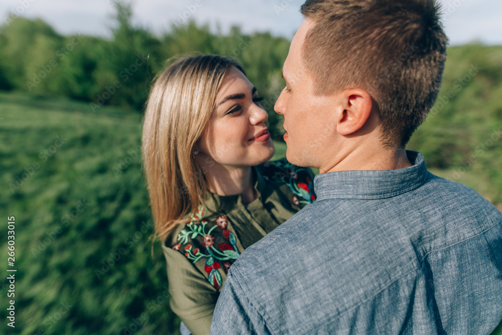Loving guy and girl kisses in nature.concept of love story outdoor.Lovers Walking in spring park.stylish couple in love hugging on a walk in spring Loving guy and girl kisses in nature.concept of love story outdoor.Lovers Walking in spring park.stylish couple in love hugging on a walk in spring