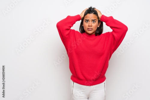 Young Colombian girl with red sweater frustrated and takes hands on head © luismolinero