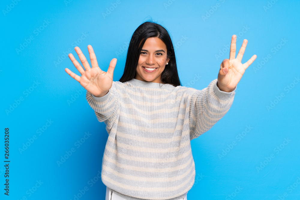 Young Colombian girl with sweater counting eight with fingers Young Colombian girl with sweater counting eight with fingers
