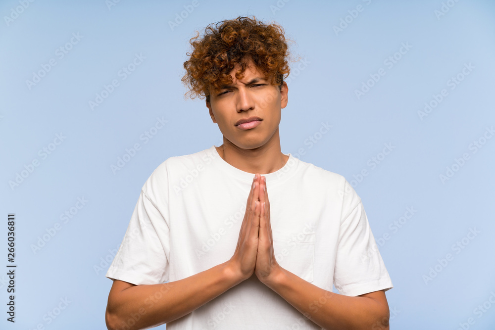 Young african american man with white shirt pleading Young african american man with white shirt pleading