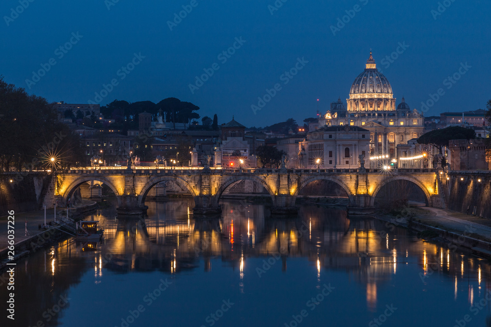 Tiber and St Peters Basilica with Aurelius Bridge or Ponte Sisto Bridge at the blue hour with artificial lighting and reflections. Stone bridge at night over river Tiber in the historic center of Rome