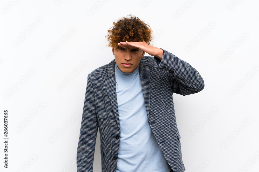 Fashion african american man over isolated white wall looking far away with hand to look something Fashion african american man over isolated white wall looking far away with hand to look something
