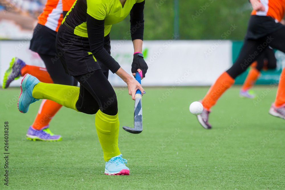 three women battle for control of ball during field hockey game three women battle for control of ball during field hockey game