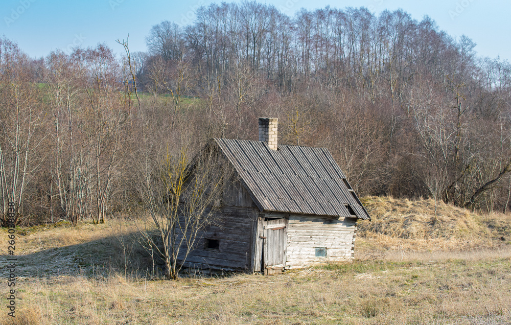 The old building of a sprawling bathhouse in a field on a farm in Latvia The old building of a sprawling bathhouse in a field on a farm in Latvia