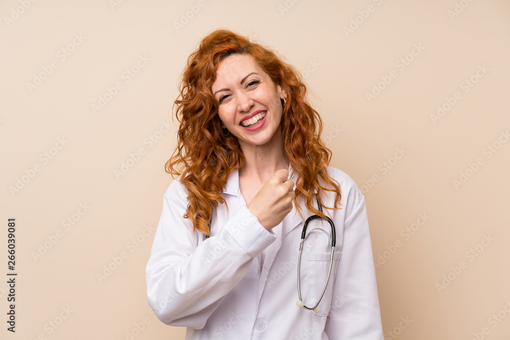 Redhead doctor woman celebrating a victory