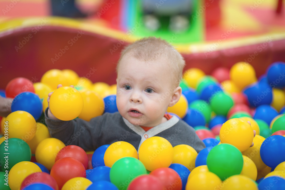 The boy sits in a pile of balls in a dry pool and plays The boy sits in a pile of balls in a dry pool and plays