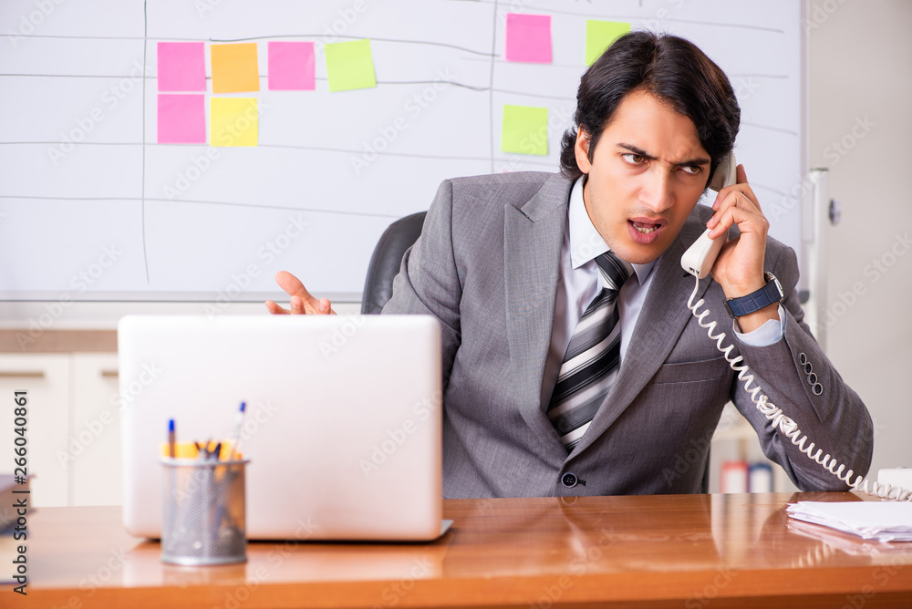 Young handsome employee working in the office Young handsome employee working in the office