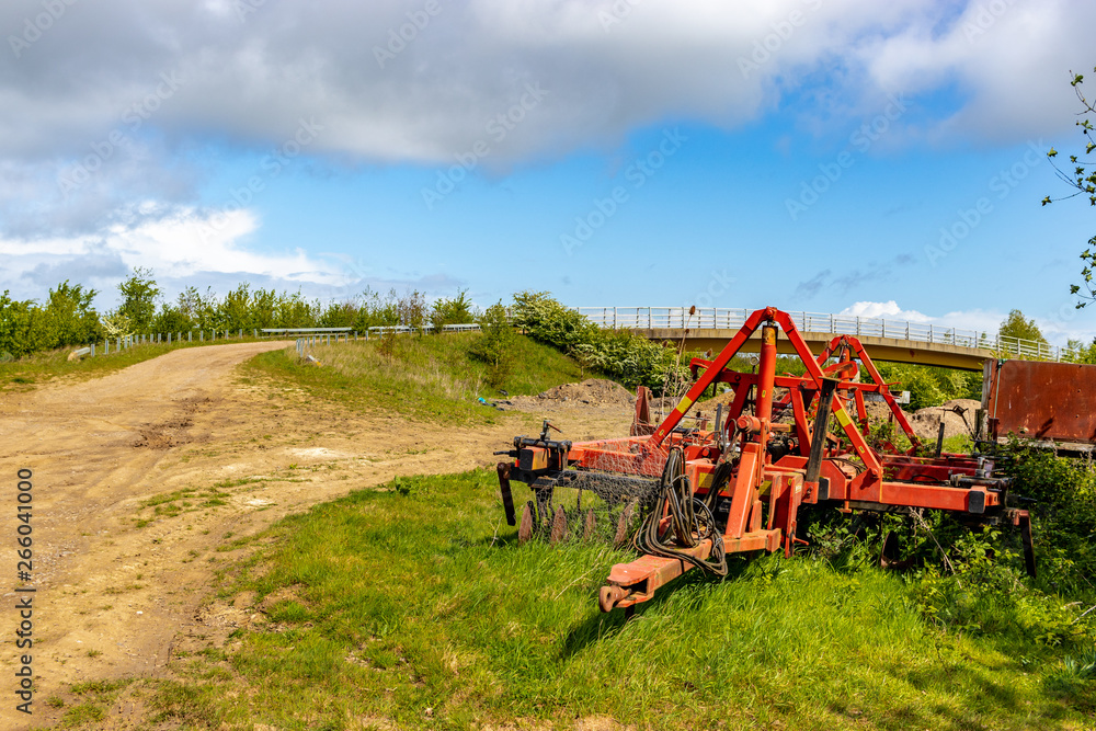 Fototapeta premium old rusty abandoned cultivator in the fields