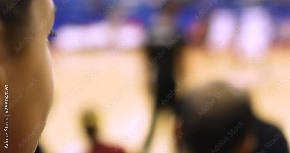 Close up of girls face in a crowd as she watches and supports a basketball team Close up of girls face in a crowd as she watches and supports a basketball team