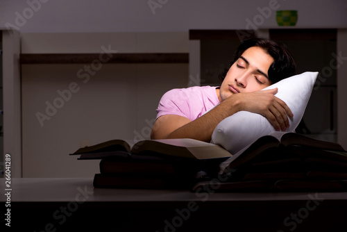 Male handsome student preparing for exams late at home 