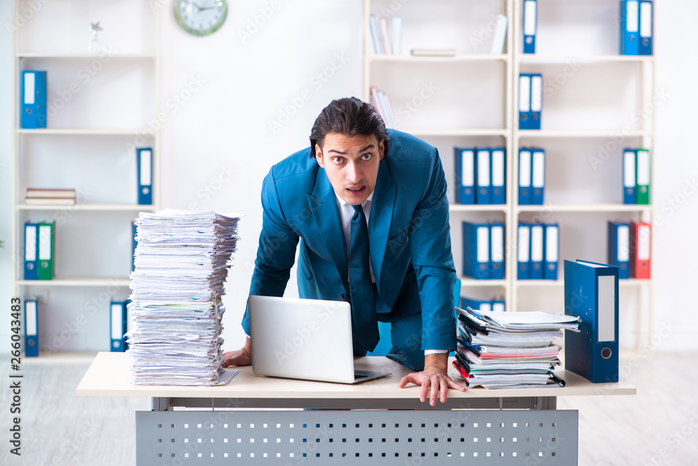 Young male employee unhappy with excessive work Young male employee unhappy with excessive work