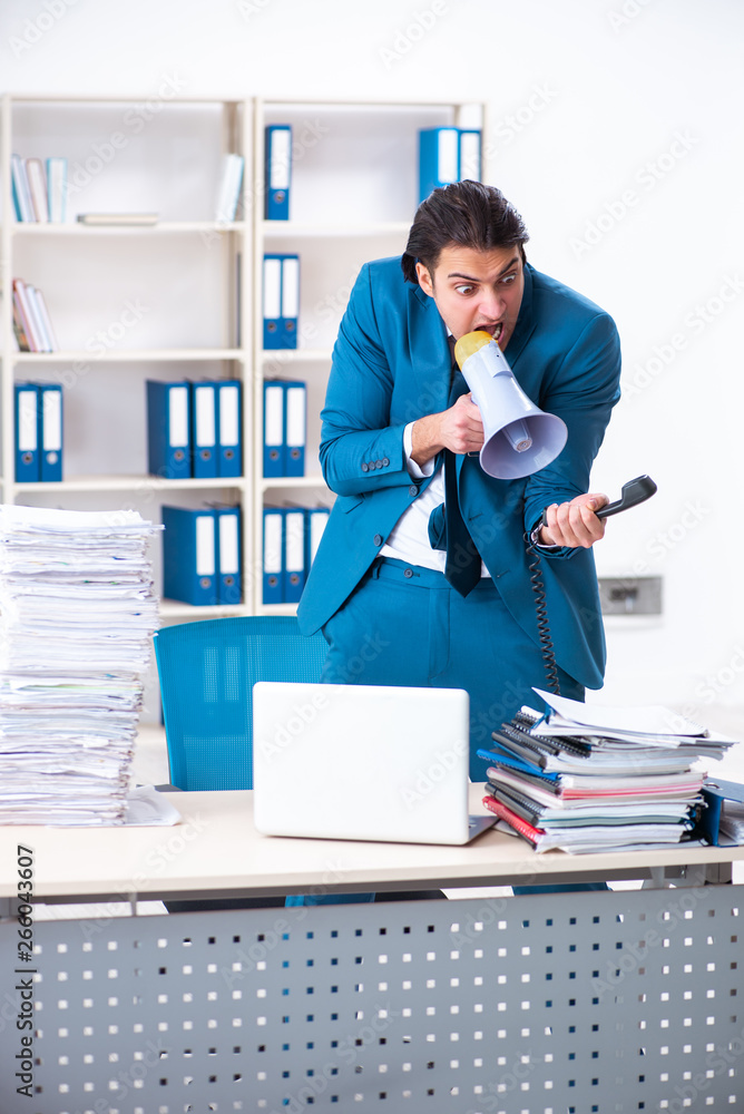 Young male employee unhappy with excessive work Young male employee unhappy with excessive work