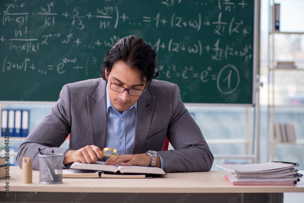 Young handsome math teacher in classroom Young handsome math teacher in classroom