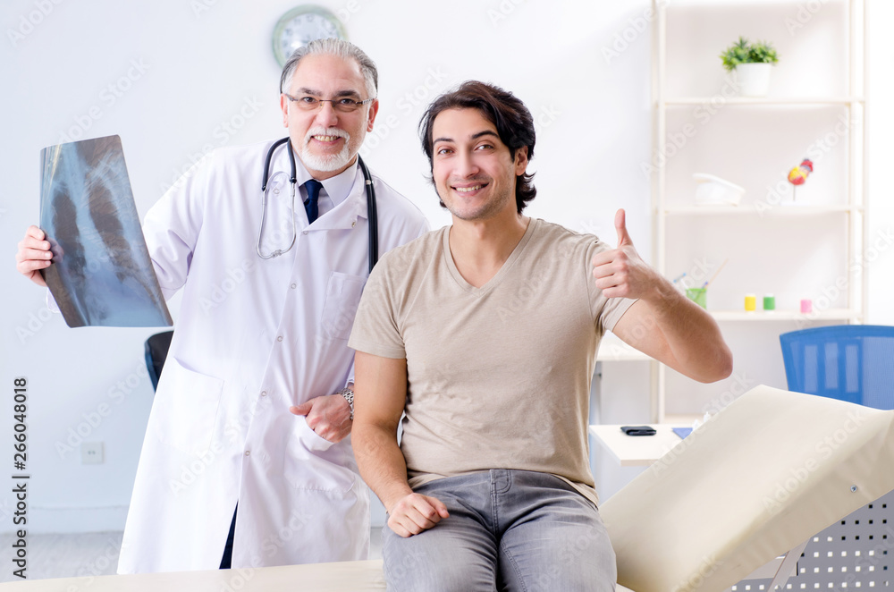 Obraz premium Young man visiting old male doctor radiologist 
