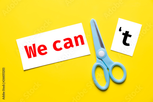 blue scissor cut white paper "we can't" to "we can" on yellow background. change to chance success concept.
