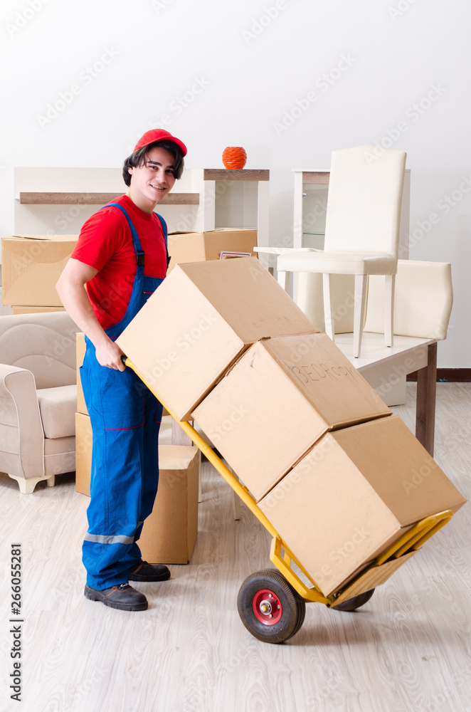 Young male contractor with boxes working indoors Young male contractor with boxes working indoors