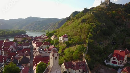Aerial circling and fly over view of medieval Durnstein castle ruin and town in Wachau valley Lower Austria along the river Danube